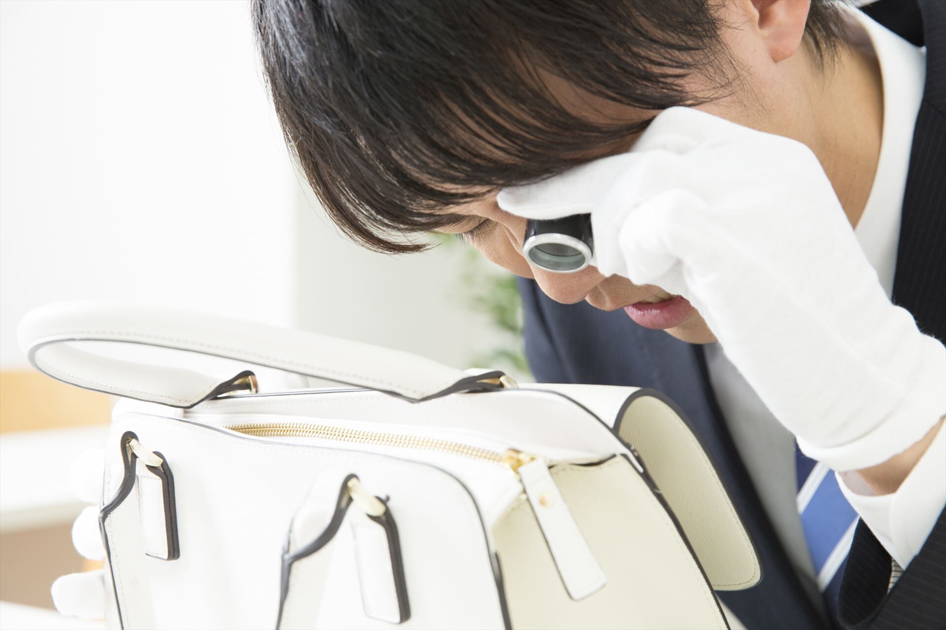 バッグに損傷がないか確認する鑑定士